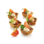 Five square savoury tartlets filled with tomatoes, cheese and fresh basil
