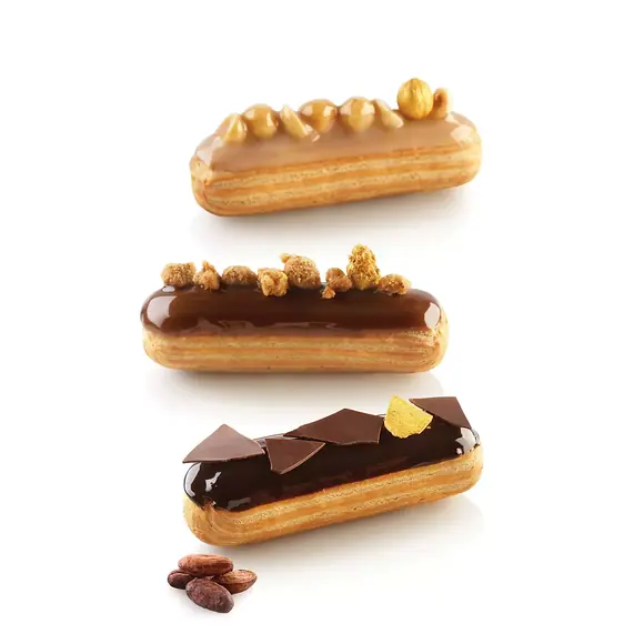 Three glazed chocolate and hazelnut éclairs displayed on a reflective black background
