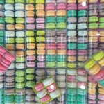 Colourful macarons arranged inside multiple clear professional display boxes