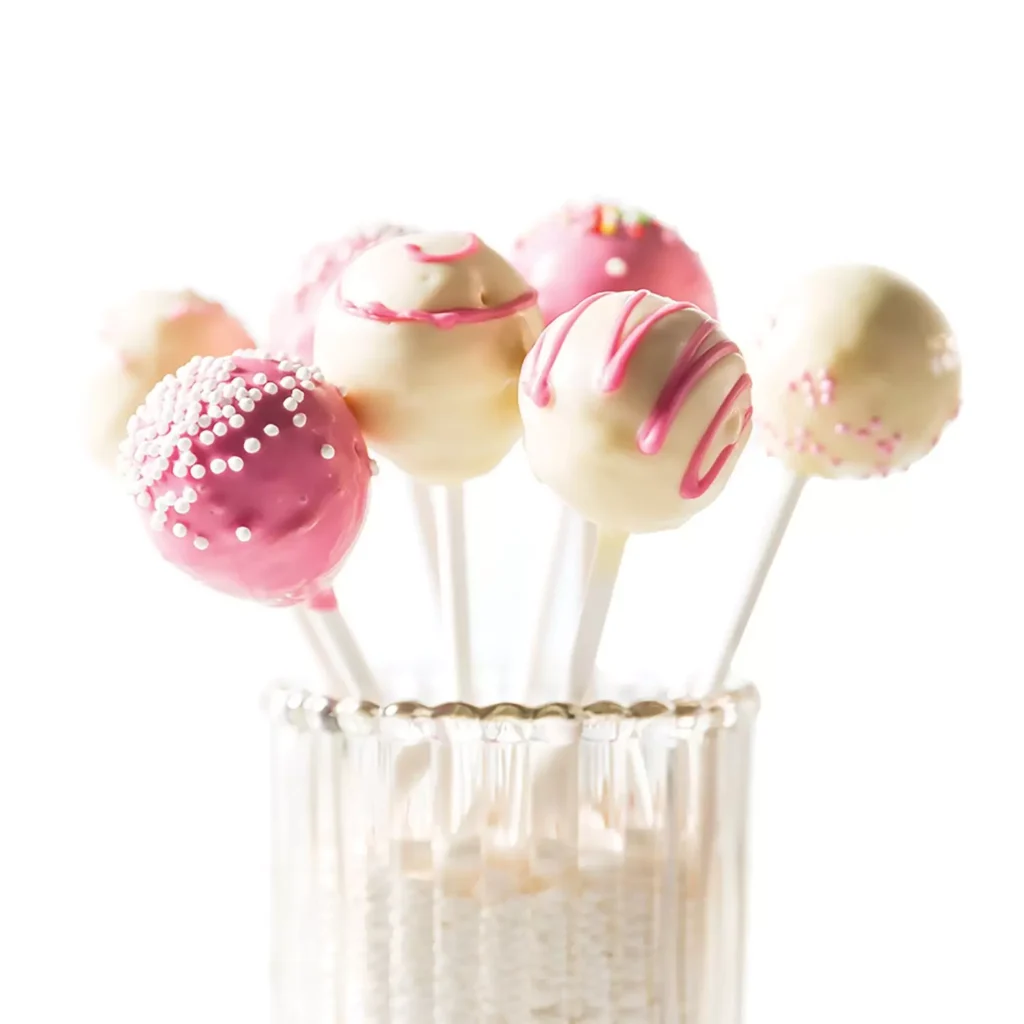 Pink and white decorated cake pops presented on long white paper sticks
