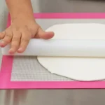 Silikomart RP06 polycarbonate rolling pin flattening white sugar paste on a pastry mat