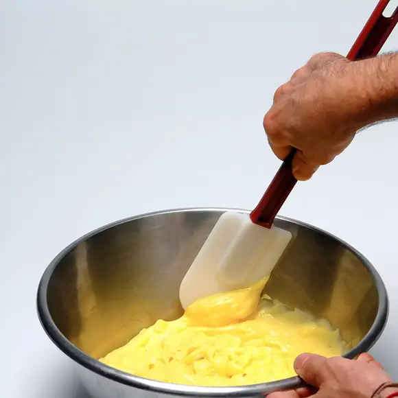 Silikomart SPS25 silicone spatula mixing yellow pastry cream in a stainless steel bowl