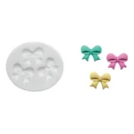 White Silikomart SLK340 silicone mould with three bow cavities and green, pink and yellow finished bows